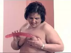 Eine dicke Lady bumst sich mit einem Dildo